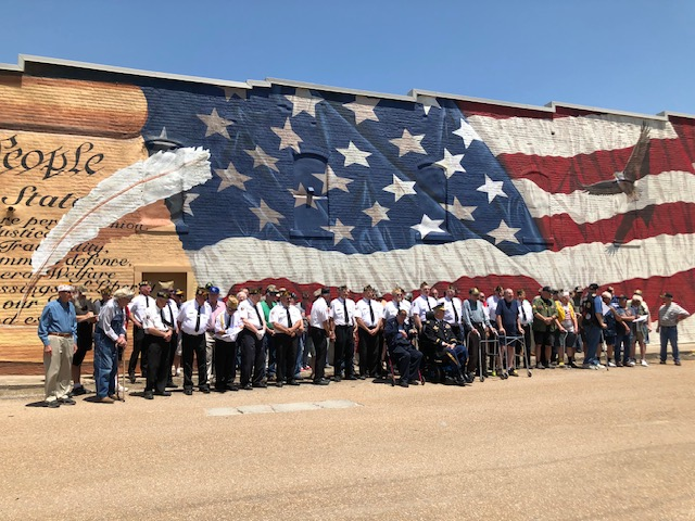 Community gathering in front of the 'We the People' American flag mural in downtown Concordia